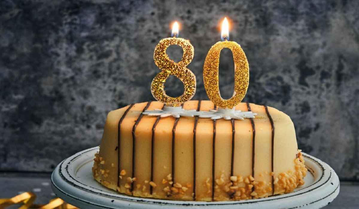 Elegant 80th birthday cake with gold accents and floral decorations